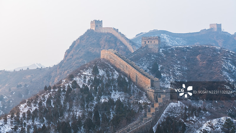 在晴朗的天空下，覆盖着新雪的中国长城图片素材