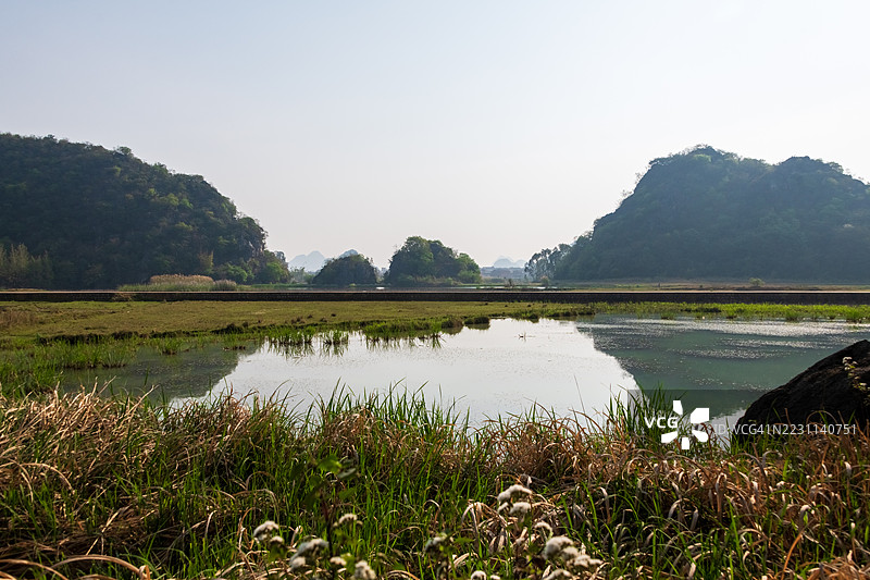 宁静的湖泊与起伏的绿丘风景图片素材