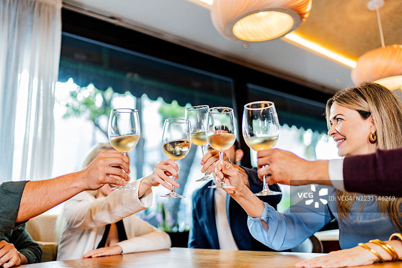同事们在餐厅的欢乐时光中举杯庆祝图片素材
