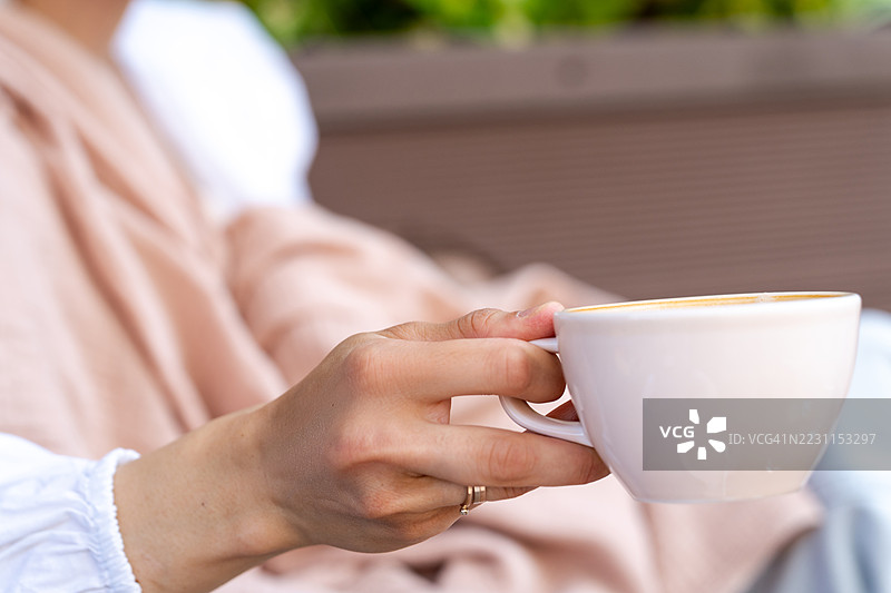 户外坐着喝咖啡的女人侧面特写图片素材