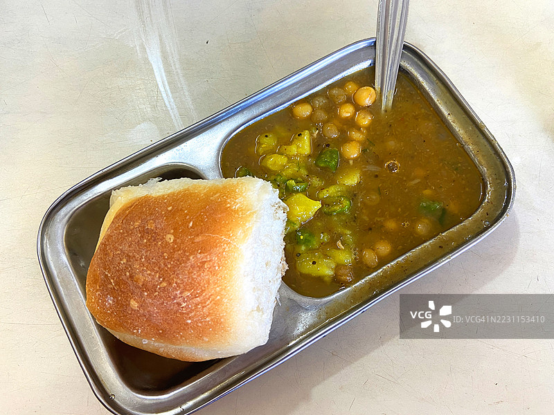 海滩附近当地餐馆里，用特色盘子盛着的果阿风味巴吉和帕夫。图片素材