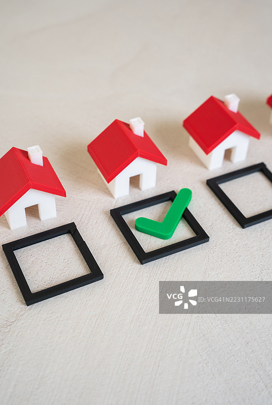 带红色屋顶的样板房和桌子上的勾选标记图片素材