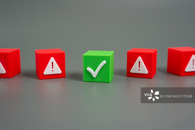 灰色背景上绿色勾选框与红色警告框的对比图片素材