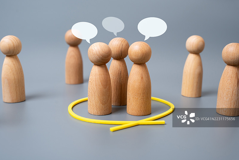 灰色背景上的圆形木质人偶与对话气泡图片素材