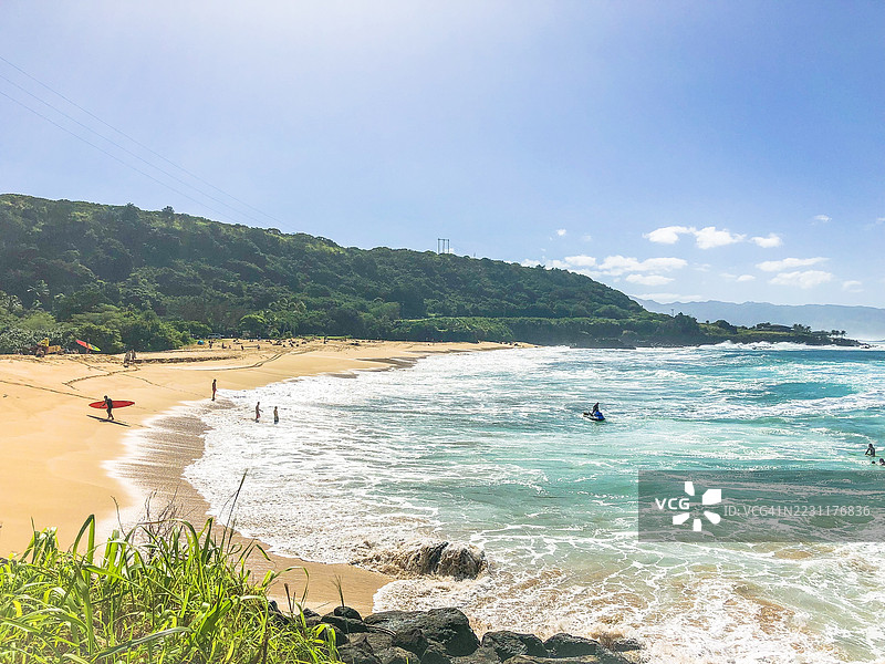 冲浪者在美国怀梅亚的热带海滩享受阳光明媚的一天图片素材