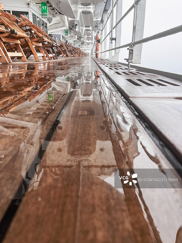 女王玛丽二号邮轮的湿甲板映照出椅子和天空，英国，英国图片素材