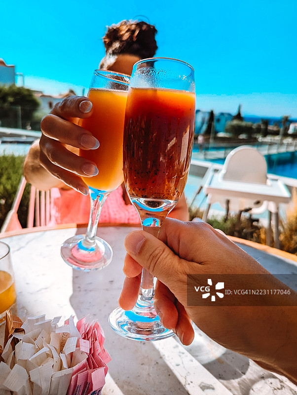 阳光明媚的户外咖啡馆里，朋友们举杯畅饮图片素材