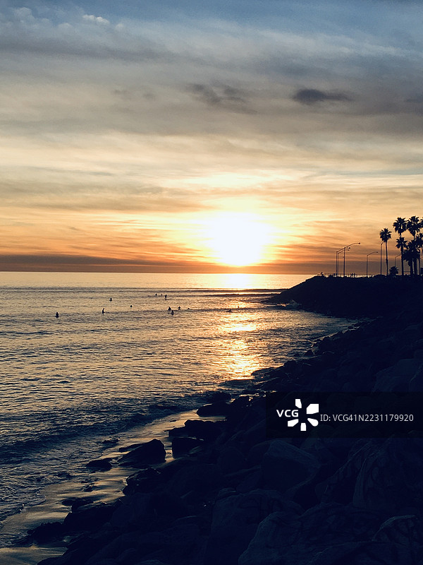 海上日落与剪影冲浪者图片素材