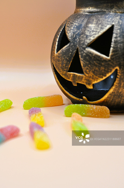 万圣节南瓜灯上放着五彩缤纷的糖果虫图片素材