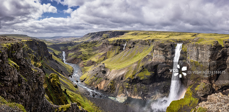 雄伟的瀑布倾泻而下，穿过崎岖的峡谷景观，冰岛图片素材