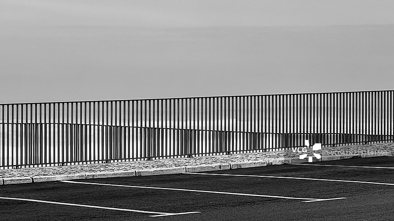 空荡荡的停车场，金属围栏和海洋景观图片素材