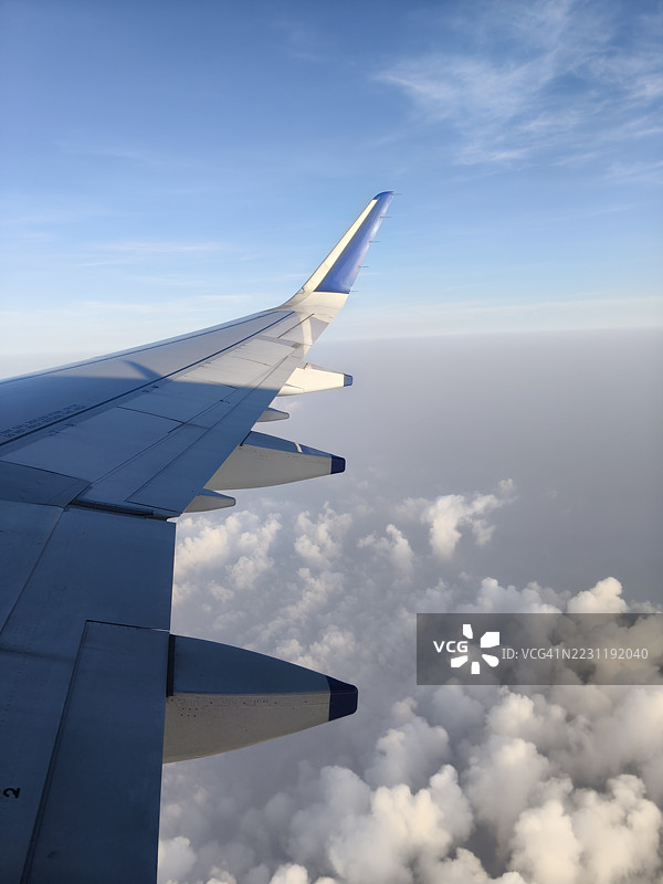 飞机机翼在日落时飞越云层图片素材