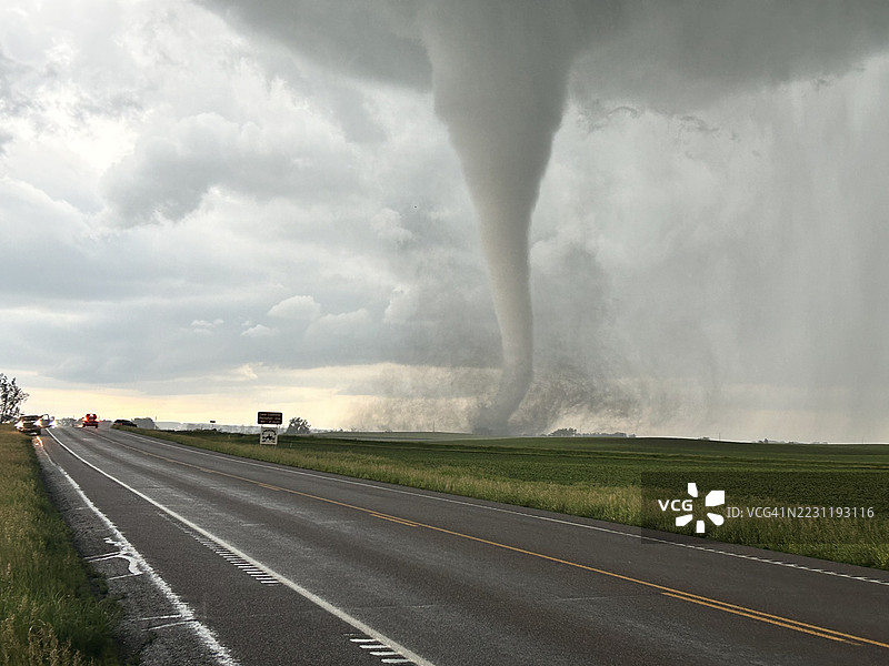 龙卷风逼近乡村风景中的空旷道路图片素材