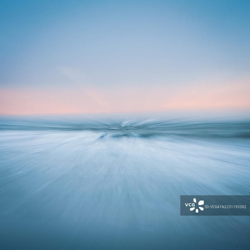 宁静的海洋在日落时分与柔和的粉彩天空图片素材