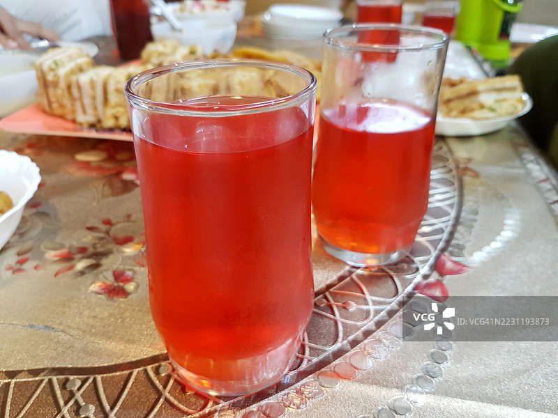 餐桌上的两杯红色热带果汁。图片素材