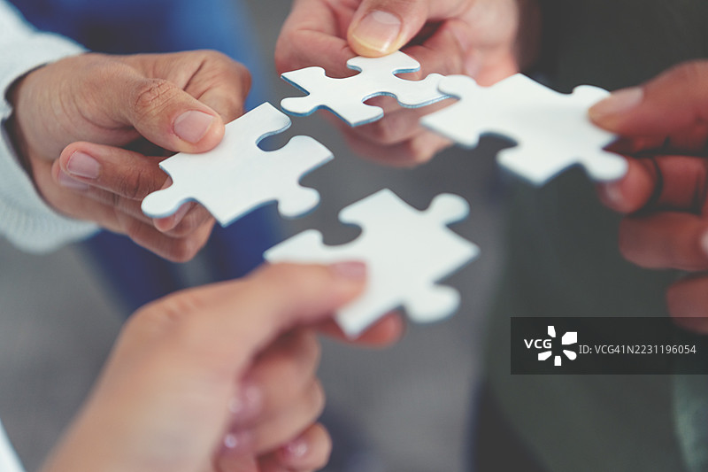 一群商务人士手持拼图碎片。商业解决方案整合合并概念。图片素材