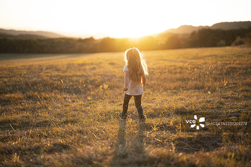 秋天的乐趣。快乐的孩子在日落时分大自然中奔跑图片素材