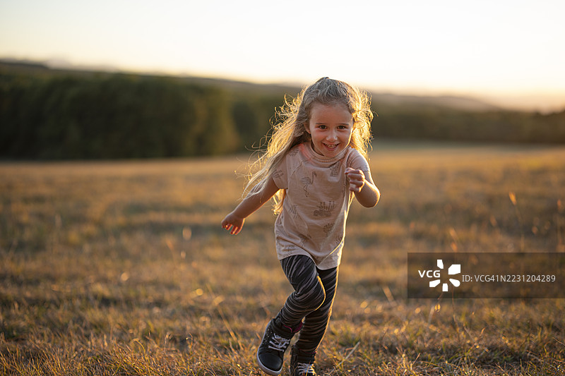 秋天的乐趣。快乐的孩子在日落时分的自然中奔跑图片素材