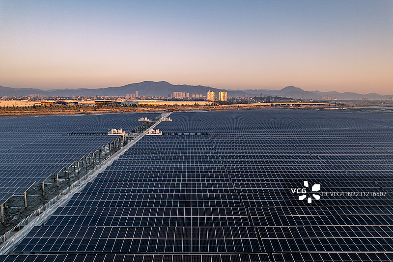 日出时分泥滩上的光伏太阳能发电厂鸟瞰图图片素材