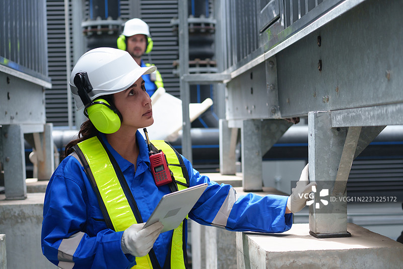 工程师正在检查大型工业建筑的水冷却塔空调，这是用于控制空气系统的水冷却塔空气冷却器HVAC。图片素材