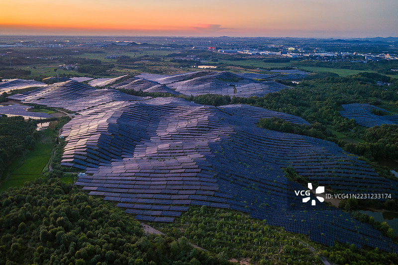 日落时分山坡上的太阳能光伏板图片素材