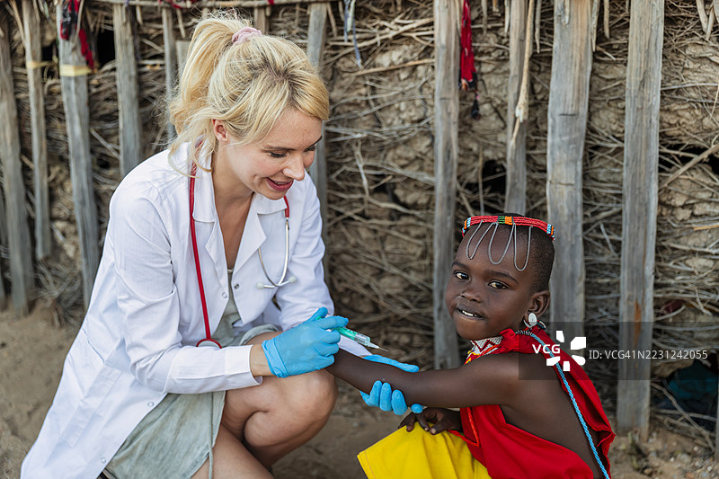 医生正在为肯尼亚小村庄的一位小女孩注射。图片素材