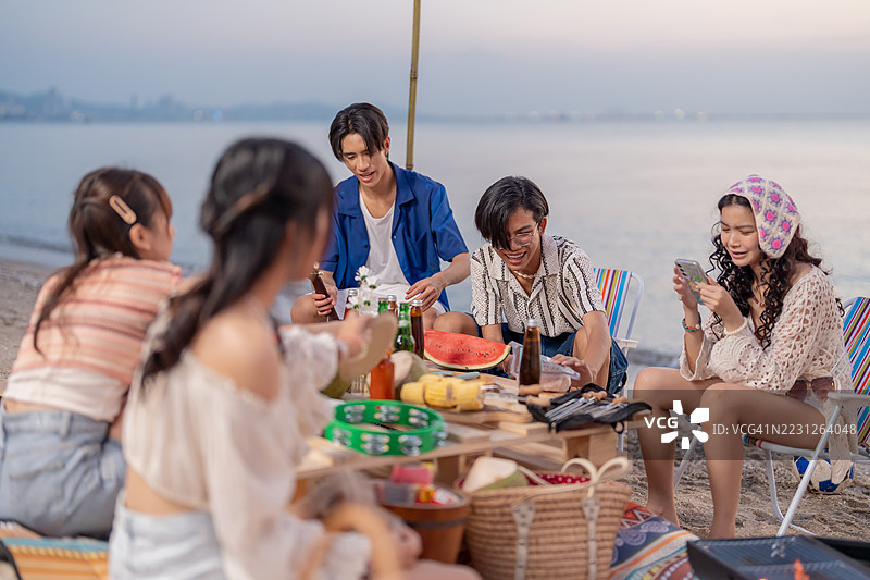 一群亚洲人在海滩上与朋友聚会。夏季假期的生活方式。图片素材