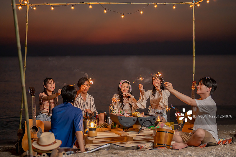 一群亚洲人在海滩上与朋友聚会。夏季假期的生活方式。图片素材