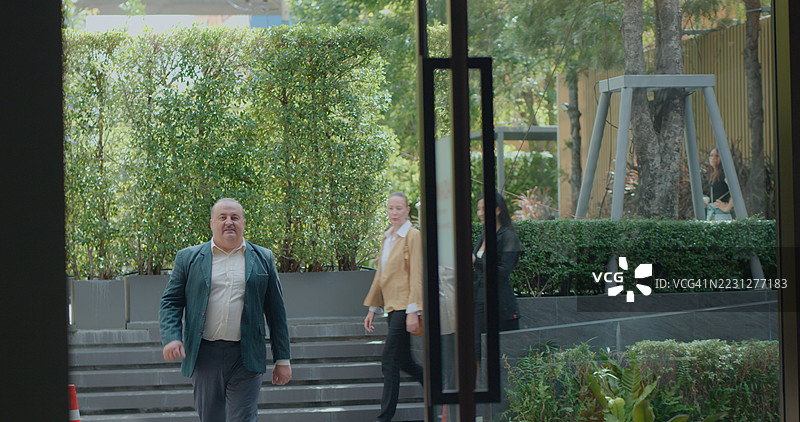 客人在豪华酒店入口外与礼宾人员一起走动。专业的酒店欢迎服务、旅行到达、客户关怀和客户支持概念。图片素材