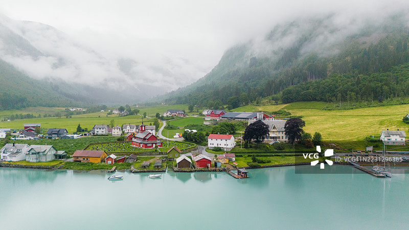 宁静的夏季山景下，峡湾旁的如画斯堪的纳维亚村庄鸟瞰图图片素材