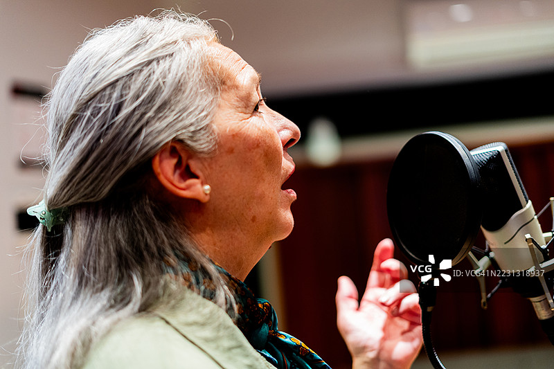 在音乐工作室里唱歌的老年女性图片素材