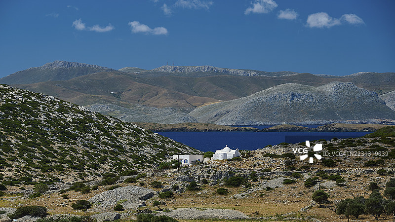 阿吉奥斯·约翰尼斯·神学家的教堂，白色小教堂坐落在广阔的丘陵景观中，俯瞰蓝色海洋，瓦伊湾，阿斯提帕利亚，德德卡尼斯，希腊群岛，希腊图片素材