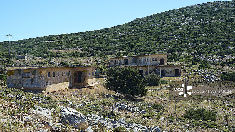 废弃建筑在灌木丛生的丘陵景观中，失落之地，意大利旧军事营地，二战，第二次世界大战，圣乔治，阿斯提帕莱亚，阿斯提帕莱亚，阿斯提帕莱亚，佐泽卡尼群岛，希腊群岛，希腊图片素材