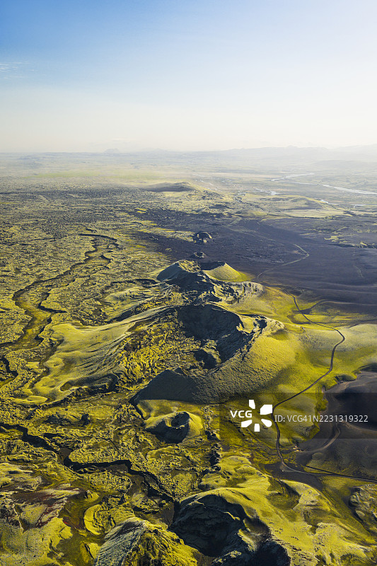 高空俯瞰荒凉的火山口和蜿蜒的小径，构成了一幅超现实的风景，苔藓般的绿色与黑色土地相交融，冰岛高地。图片素材