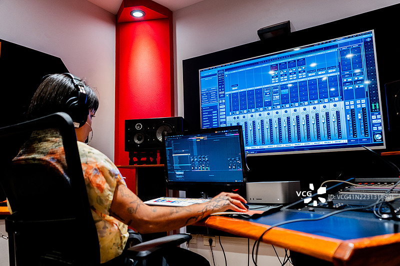年轻的女性音乐制作人在音乐工作室使用电脑图片素材
