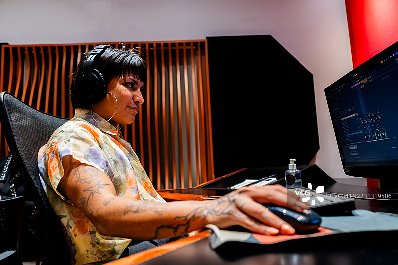 年轻的女性音乐制作人在音乐工作室使用电脑图片素材