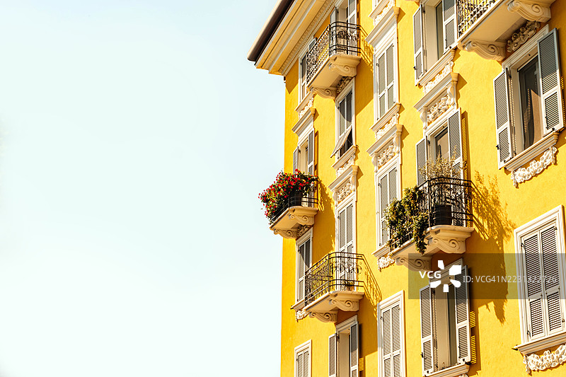 意大利拉帕洛的黄色建筑，配有优雅的阳台和盛开的花朵图片素材