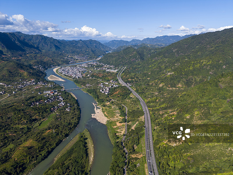 河流和公路穿过郁郁葱葱的绿地的鸟瞰图图片素材