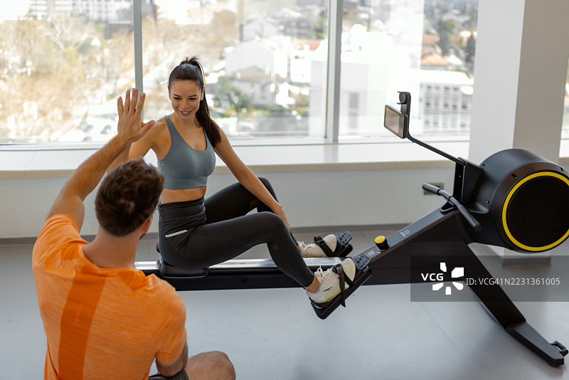 健身教练在现代健身房鼓励女性客户图片素材