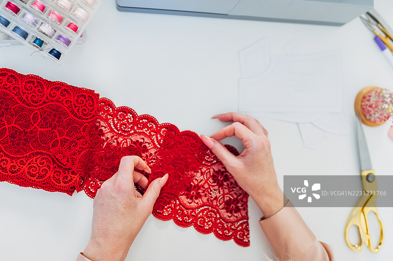 时尚设计师正在设计红色蕾丝内衣图片素材
