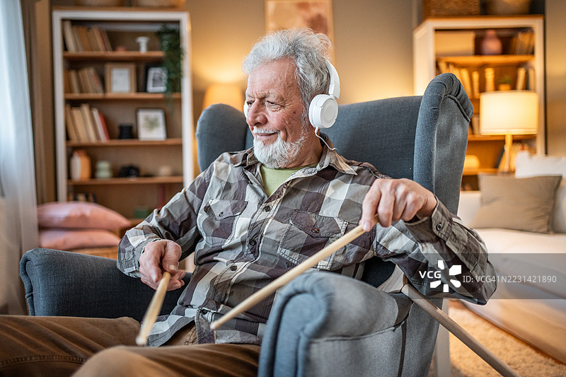 老年人享受音乐，在家中打空气鼓图片素材