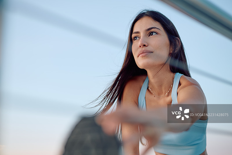 年轻女性在户外训练后伸展身体图片素材