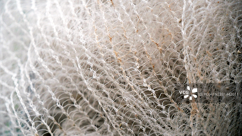 脏尼龙网的网眼特写。聚焦于前景。粗糙的纹理。阳光。自然色彩。法国巴黎。图片素材