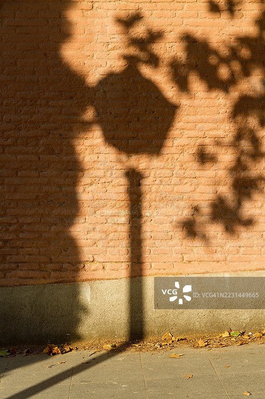 街灯的影子投射在砖墙上图片素材