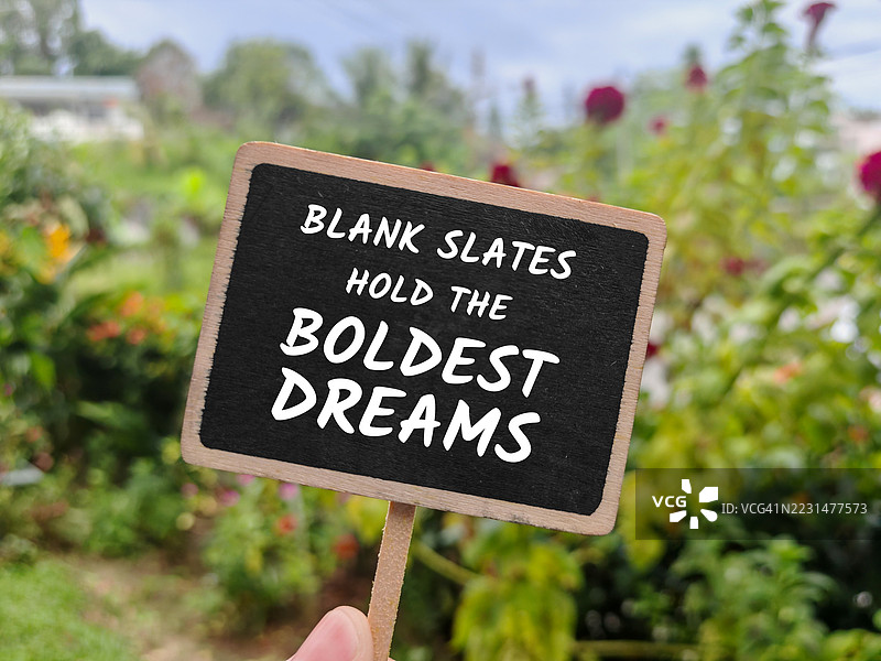 手握励志黑板标志的花园图片素材