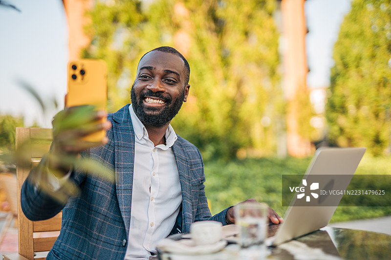微笑的商人在户外工作时自拍图片素材
