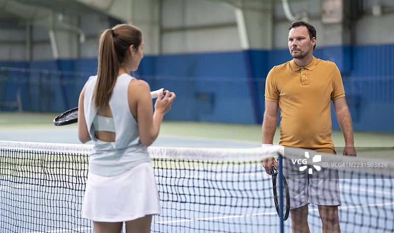 男性网球教练与女性学生交谈图片素材