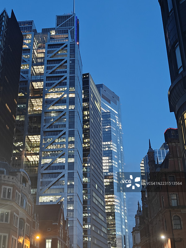 伦敦，英国，城市中黄昏天空下的灯光闪烁的摩天大楼图片素材