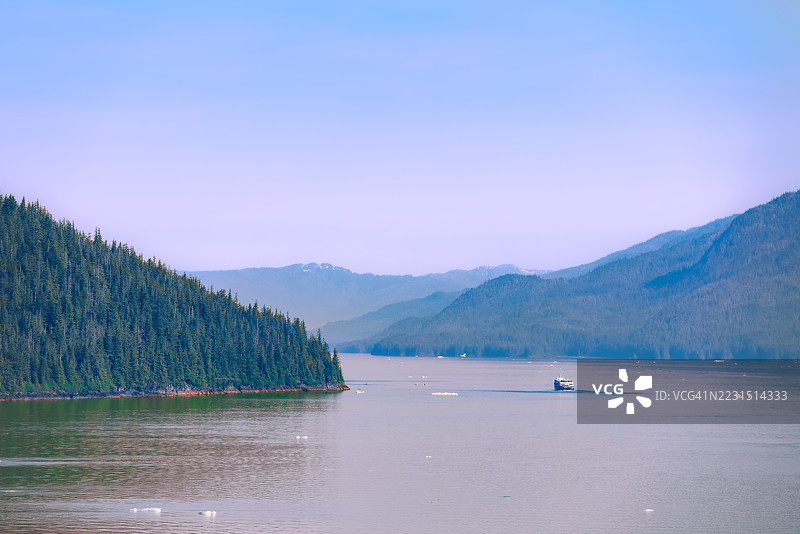 宁静的湖泊与森林环绕的山脉和一只小船图片素材