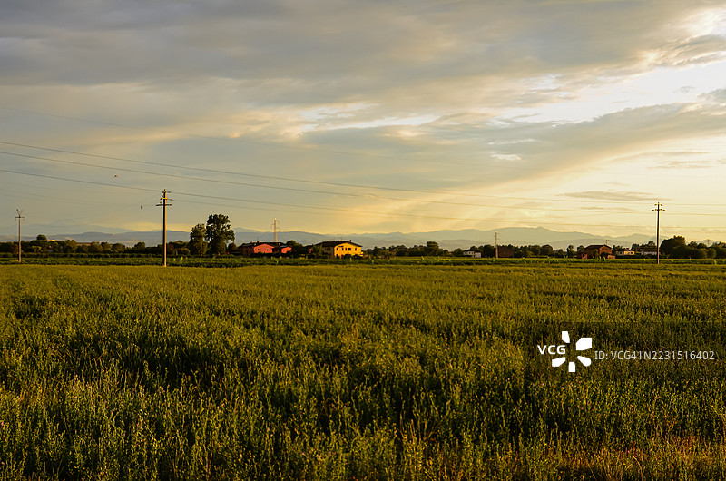 意大利诺南托拉的乡村田野上空的日落，远处有房屋。图片素材
